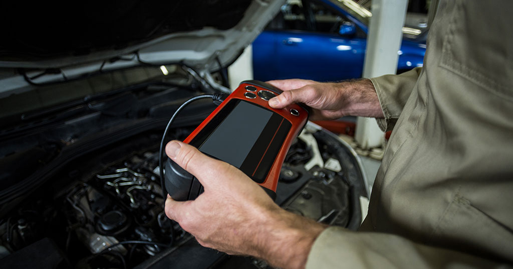 homem segurando um osciloscópio para fazer o diagnóstico automotivo e solução